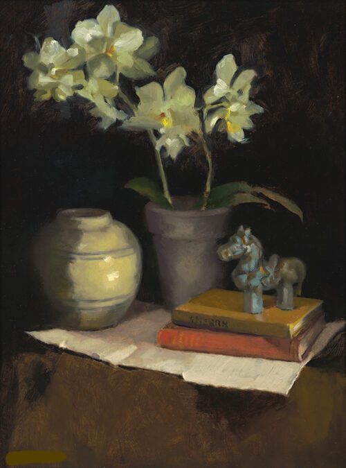 a vase, a pot of orchids, 2 books and a horse figurine are on a table
