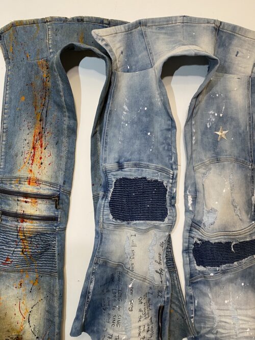 a photography of three denim pant legs with paint splattered on them