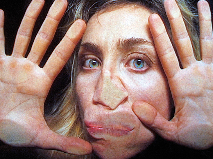 A woman with her face and hands pressed up against glass