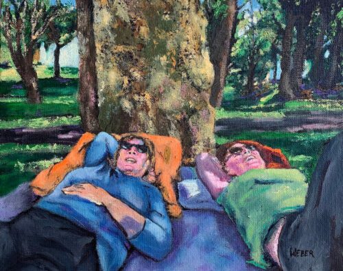 two people laying down on picnic cloth
