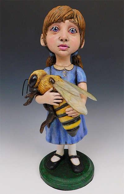 sculpture of little girl holding large bee