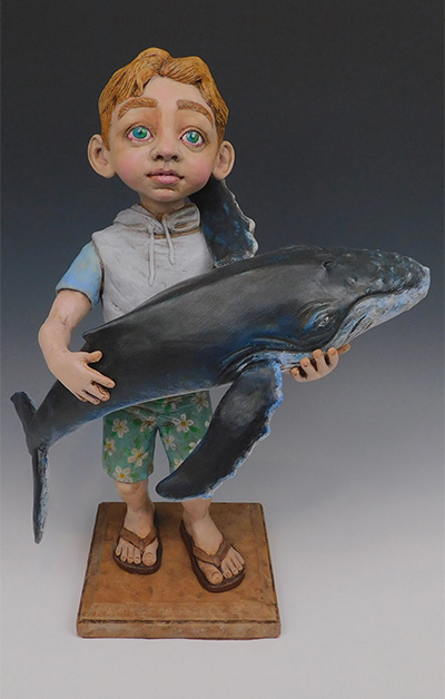 sculpture of boy holding small whale